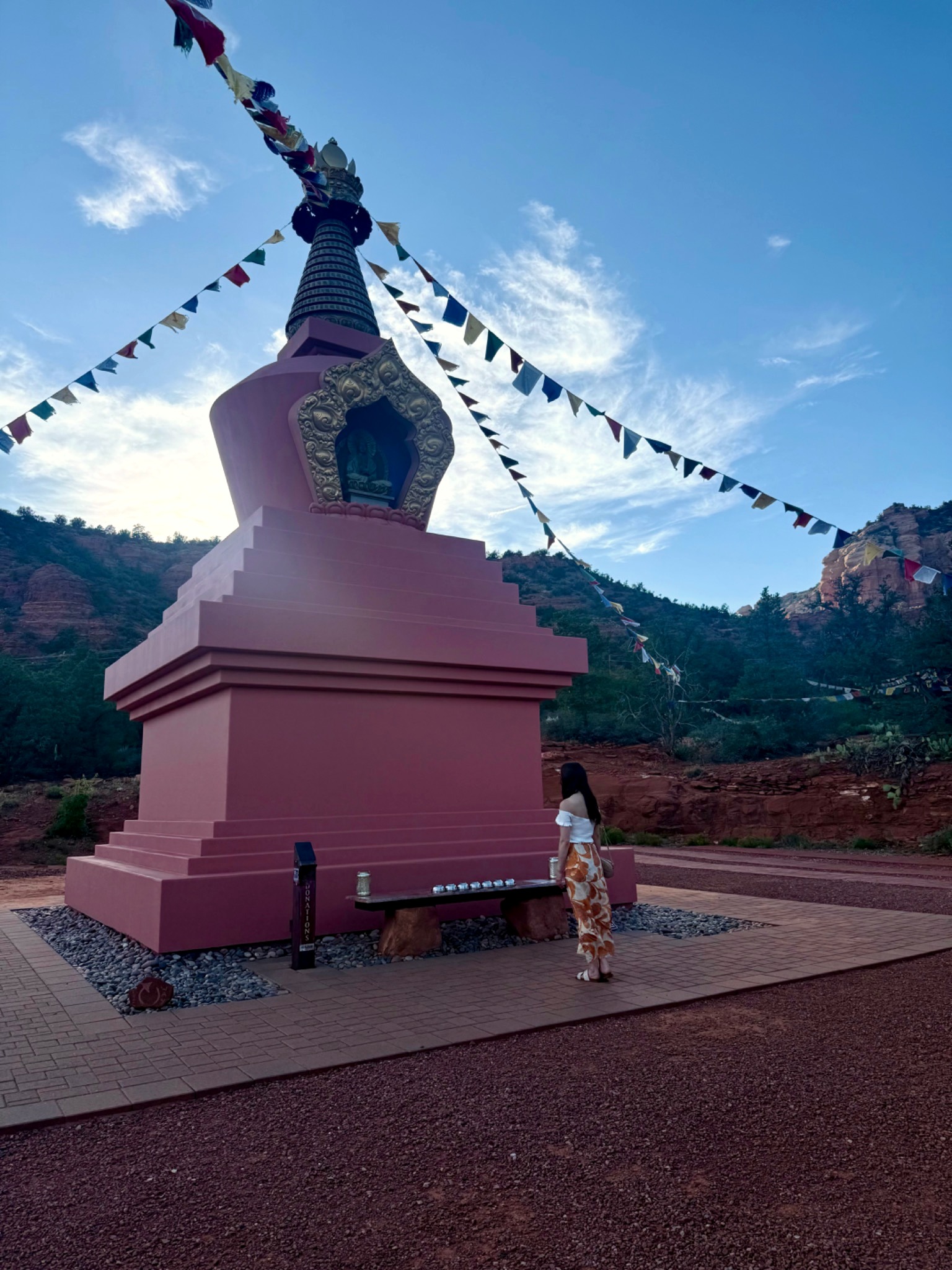 Jacquelyn standing quietly beside the Amitabha Stupa in Sedona